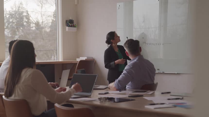 A woman is giving a presentation in the office