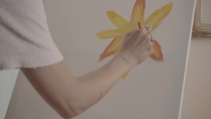 A woman is painting on the canvas