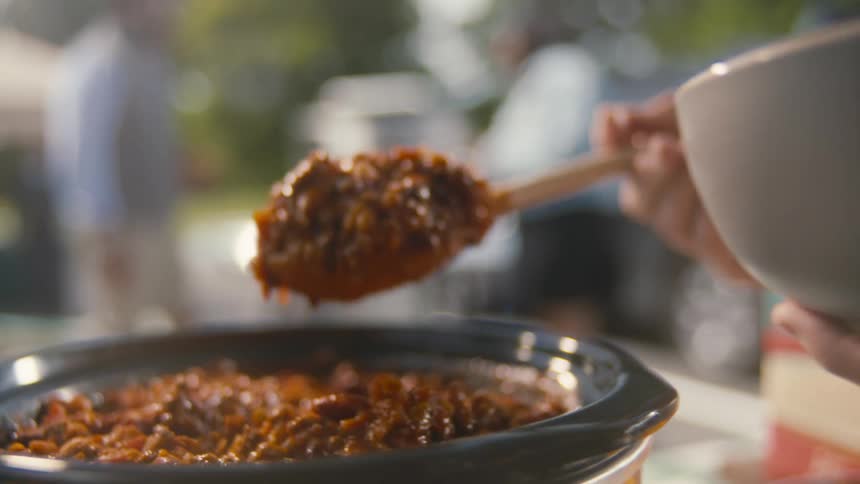 A footage of a person serving food into a bowl