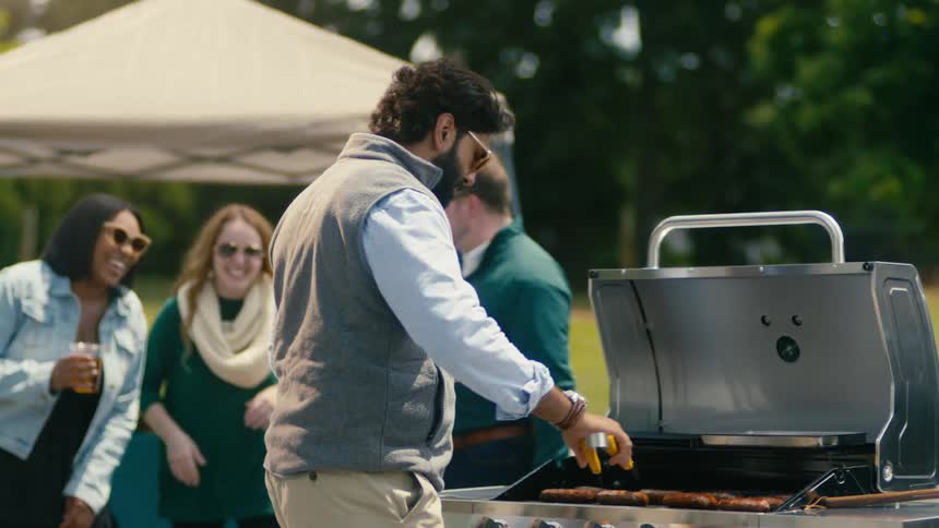 Group of friends are outdoors and grilling together