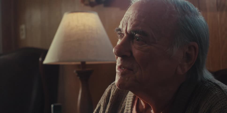 Portrait of a wideeyed elderly man sitting and paying attention to another person