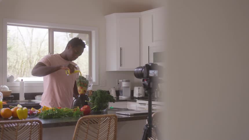 A footage of a man making a juice in the kitchen