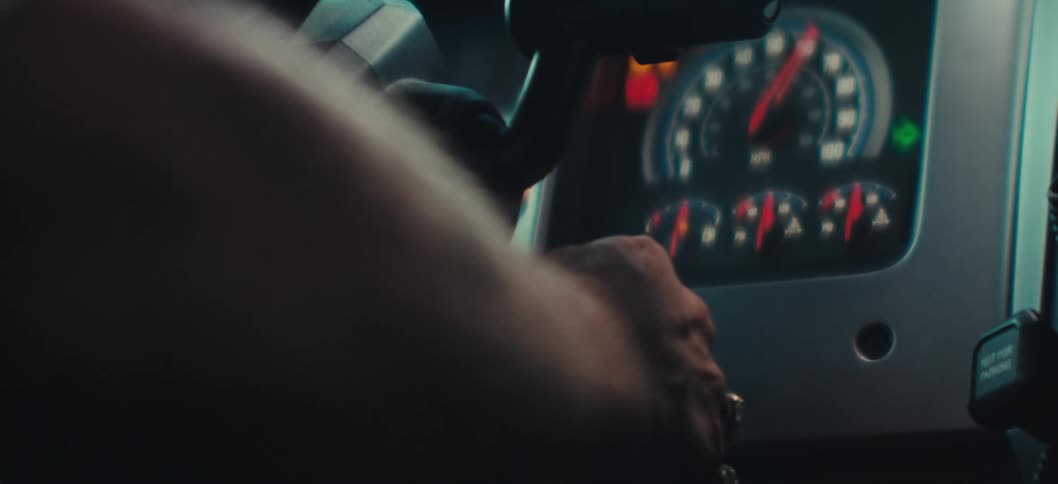 A closeup of a persons hand turning a key in a vehicle ignition as the dashboard lights illuminate and the dials activate