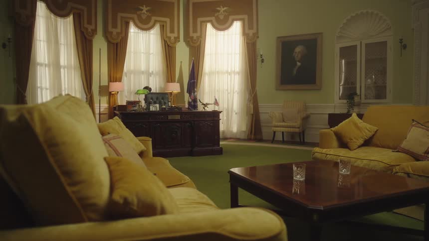 A large room with a couple sofas and a big desk