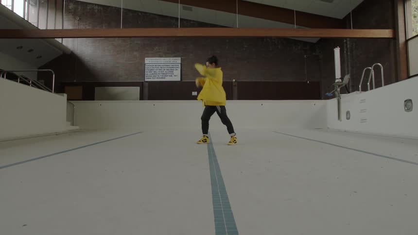 A woman in a yellow jacket begins dancing