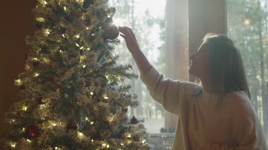 Woman decorating a happy christmas tree