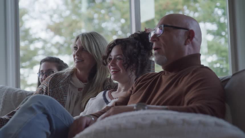 A family are talking and watching television together