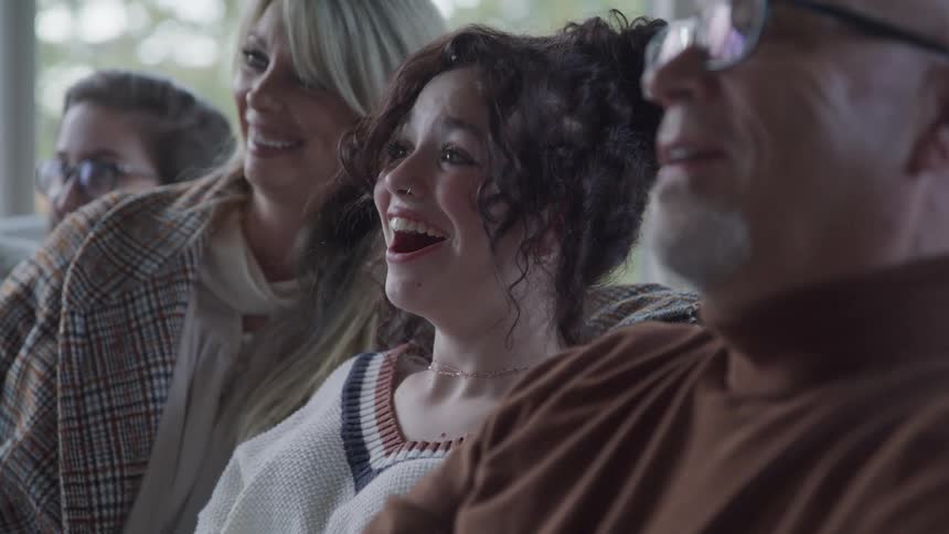 A family laugh while watching television