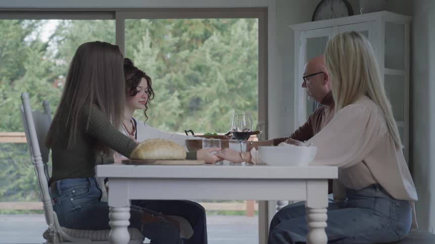 A family pray before eating a meal together