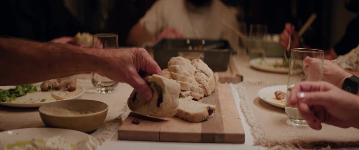Several people eating food at a family dinner