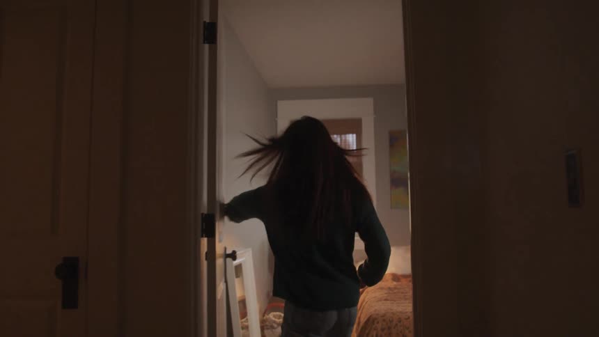 Young teenager entering the room and closing the door