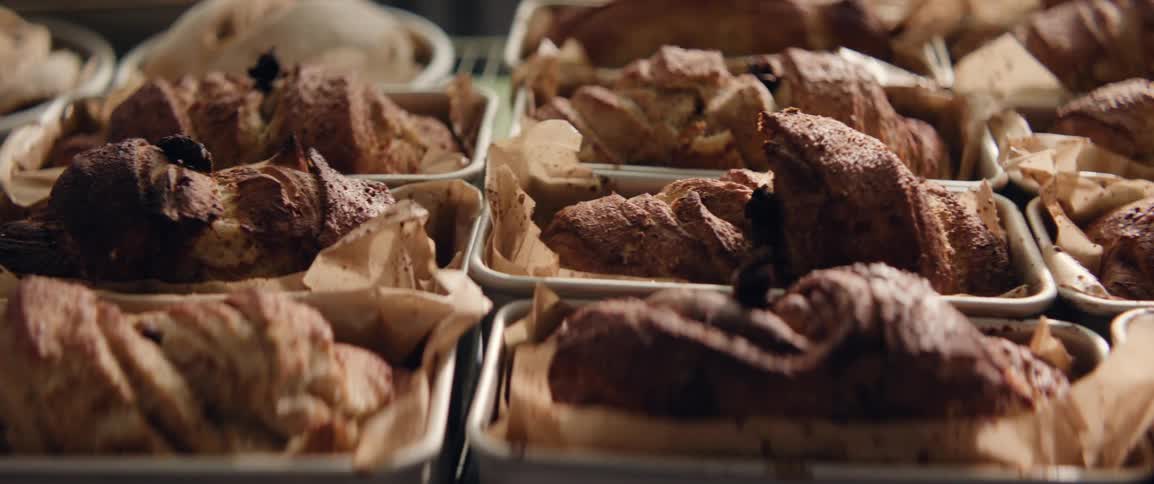 Many loaves of bread rest in their metal baking pans