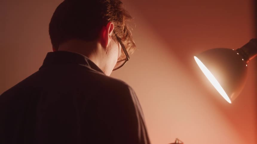 A footage of a man standing beside a lamp