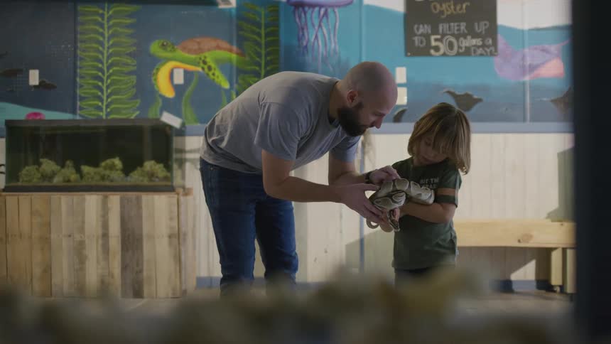 A child is holding a large snake
