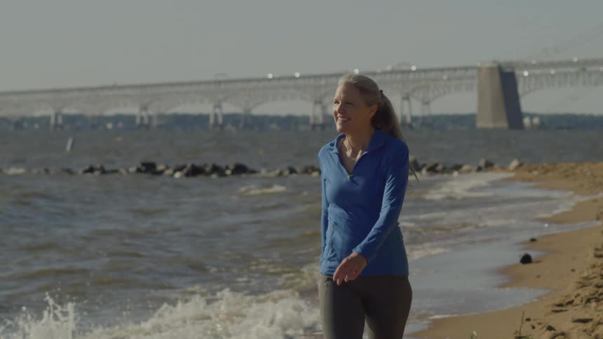 Smiling woman walking on the beach