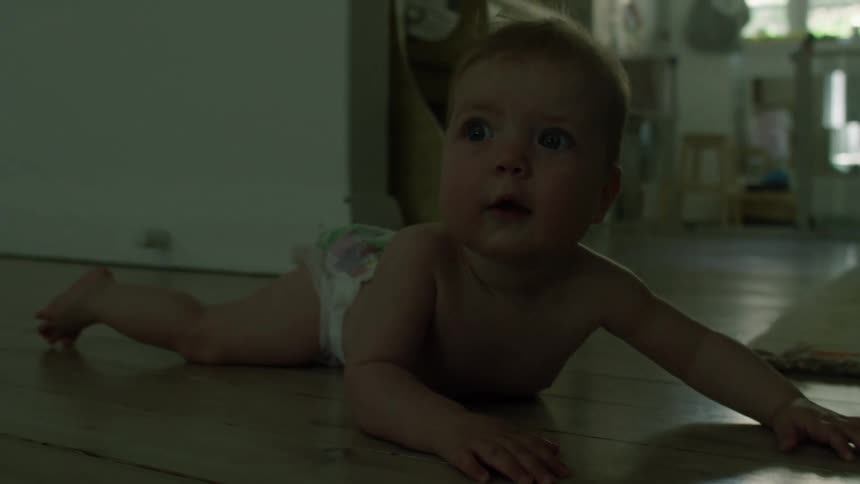 A baby is laying on the floor