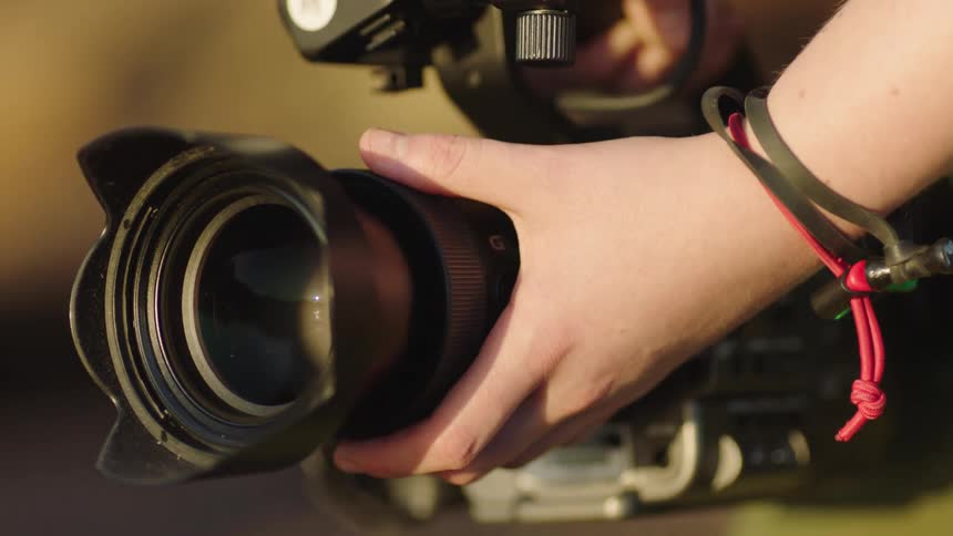 Hand using a professional video camera outdoors