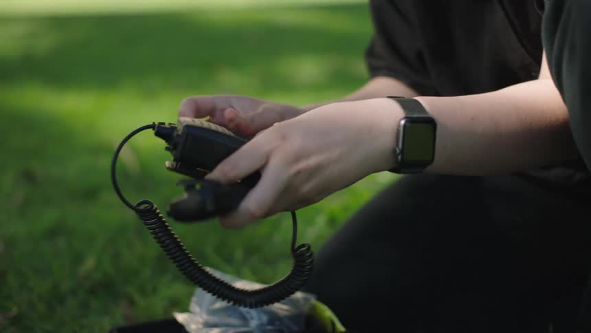 A person is removing a walkie talkie from the box