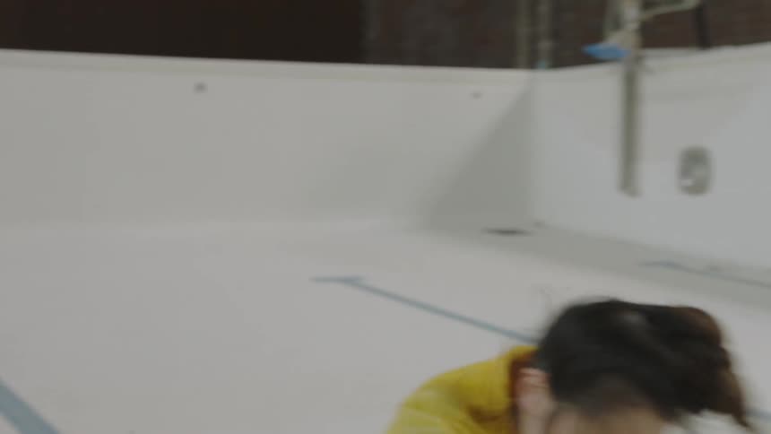 Woman dancing in an empty pool indoors