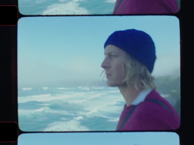 A man is looks out over the ocean on the cliff