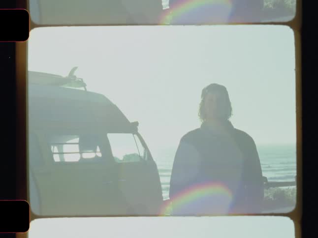 A man is standing near his van on the shore