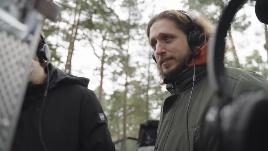 Men laughing while on an outdoor filming set