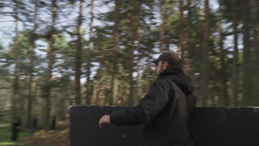 A man is carrying equipment into the forest