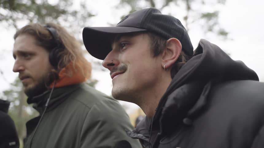 Members of a film crew stand and watch during the day