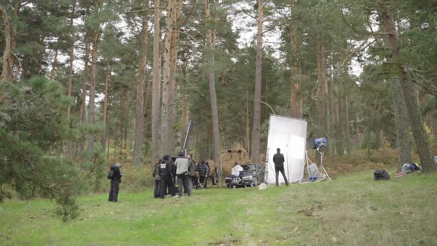 Film crew performing on a film set in a forest