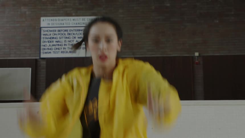Woman dances in the middle of an empty pool