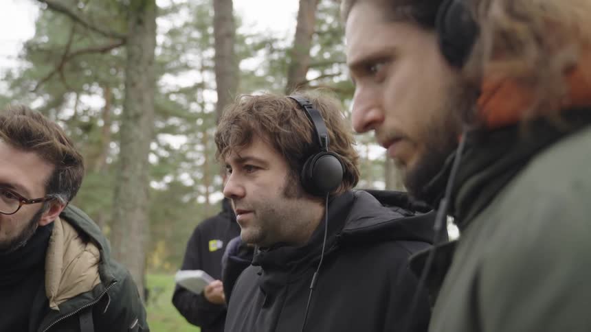Men looking at video playback on an outdoor recording set