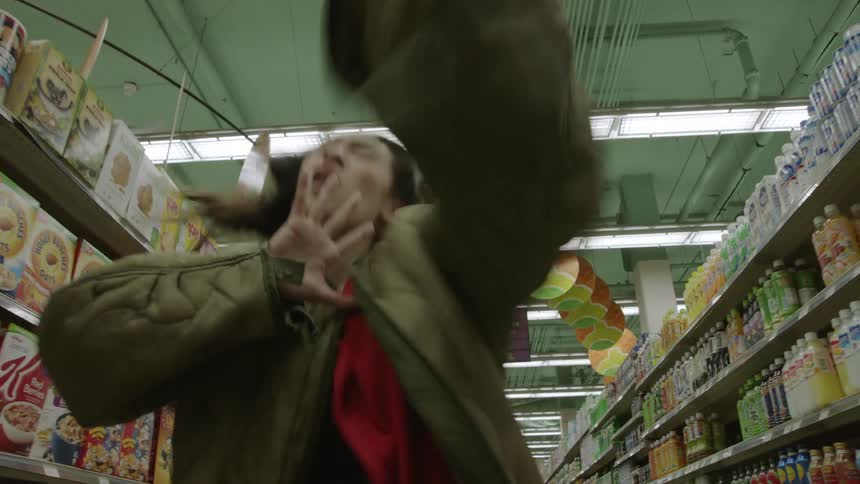 Woman dances interpretively in the aisle of a grocery store
