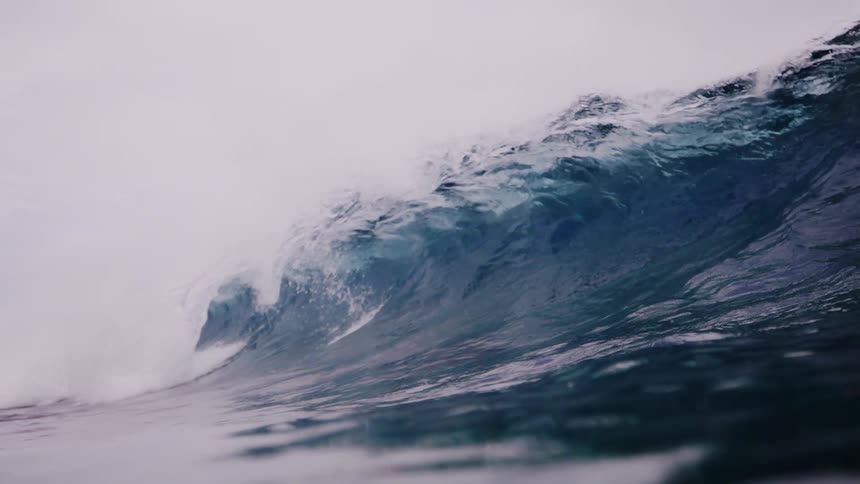 A wave pushes down underwater when it crashes