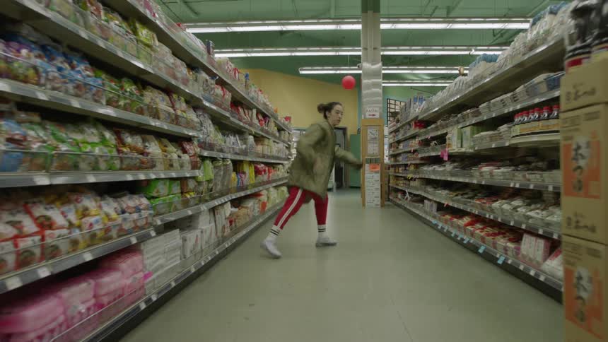 Woman dancing in the middle of a grocery store aisle