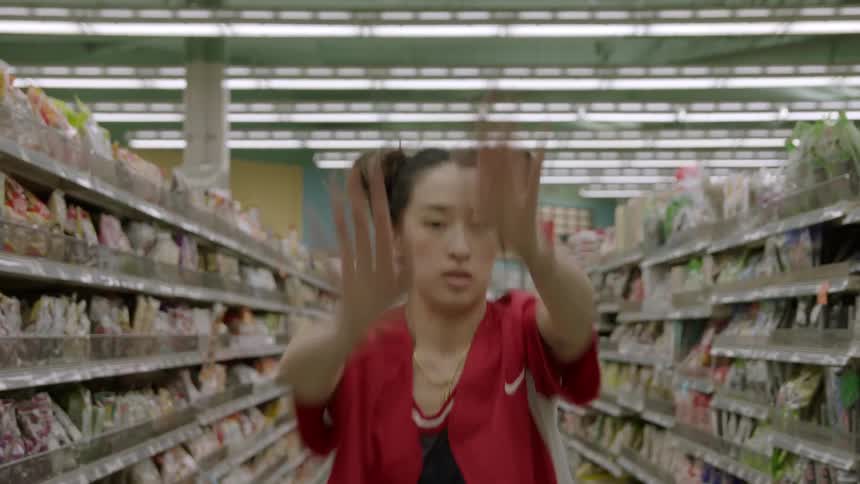 Woman dances in the aisle of a grocery store