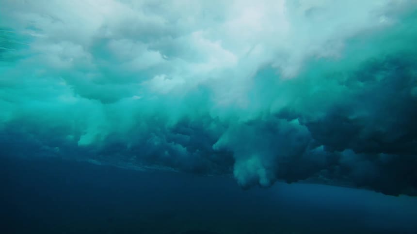 Heavy clouds move underwater as the waves crash