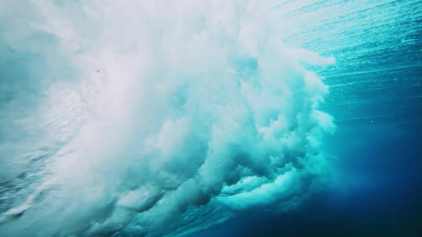 The surface of the water moves up and down as a wave crashes