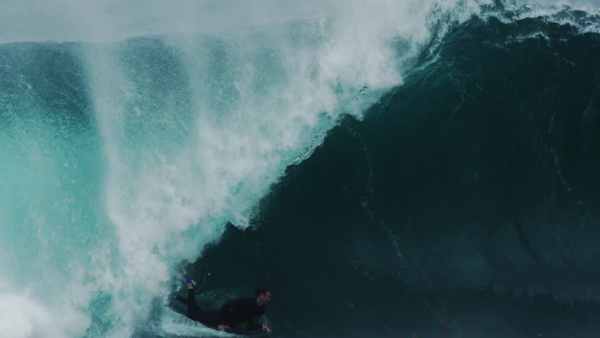 A man is body surfing on a large wave