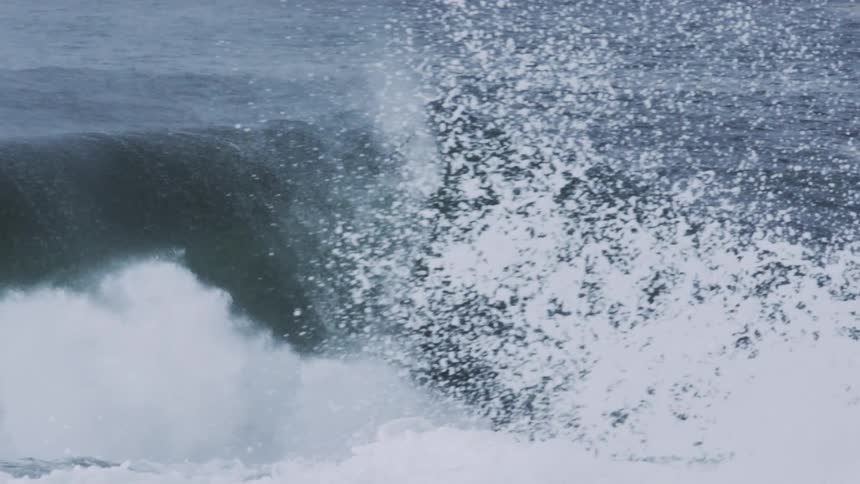 A gigantic wave crashes in the ocean and makes a huge splash