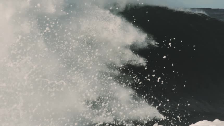 A huge sea wave breaking making a big white foam