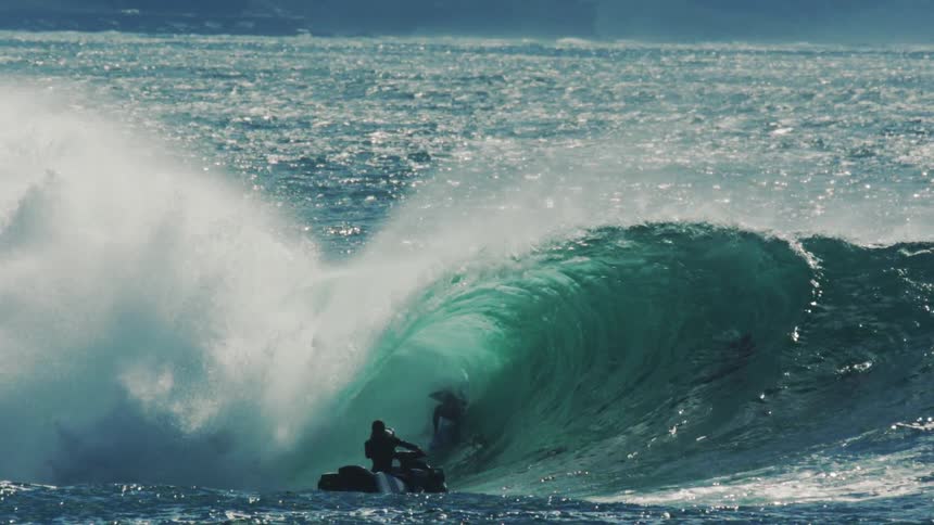 A man is bodysurfing on a large wave while being recorded
