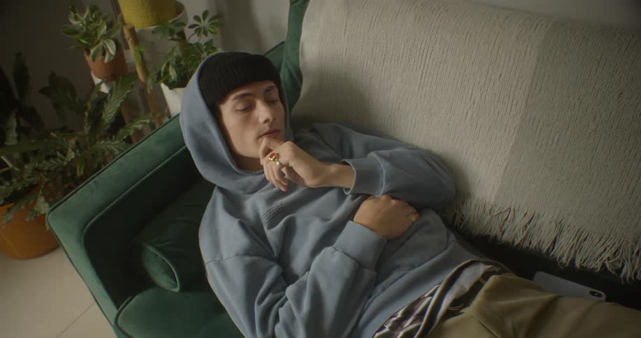 Man with eyes closed lying on the couch in thought