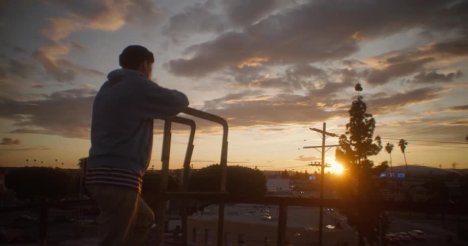 Man standing enjoying sunset and cityscape
