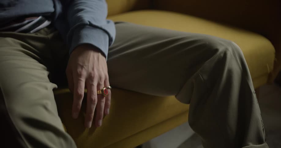 A man points while sitting on the couch