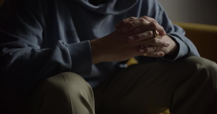 Close up of a pair of hands of a person sitting down