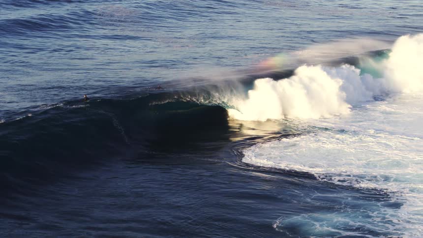 Aerial view of two surfers in a strong sea with big waves