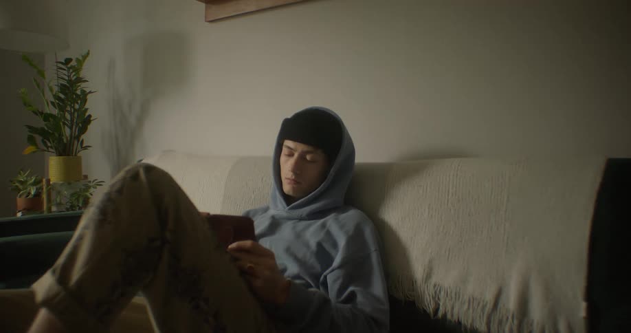 Boy sitting on a sofa with tablet in hand