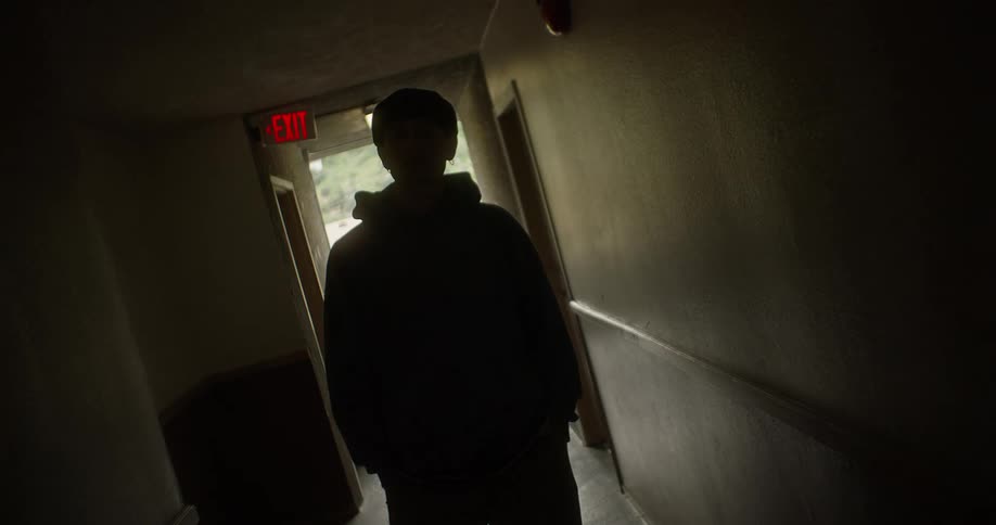 Man walking down an apartment hallway