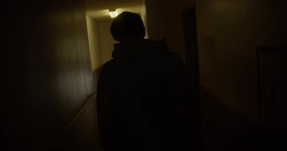 View of a man from behind walking down a hallway