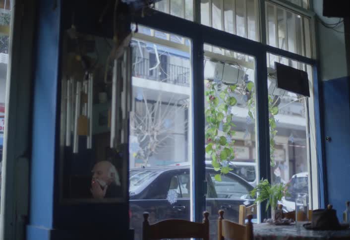 A sign is hanging inside a business window facing out toward a car parked on the street